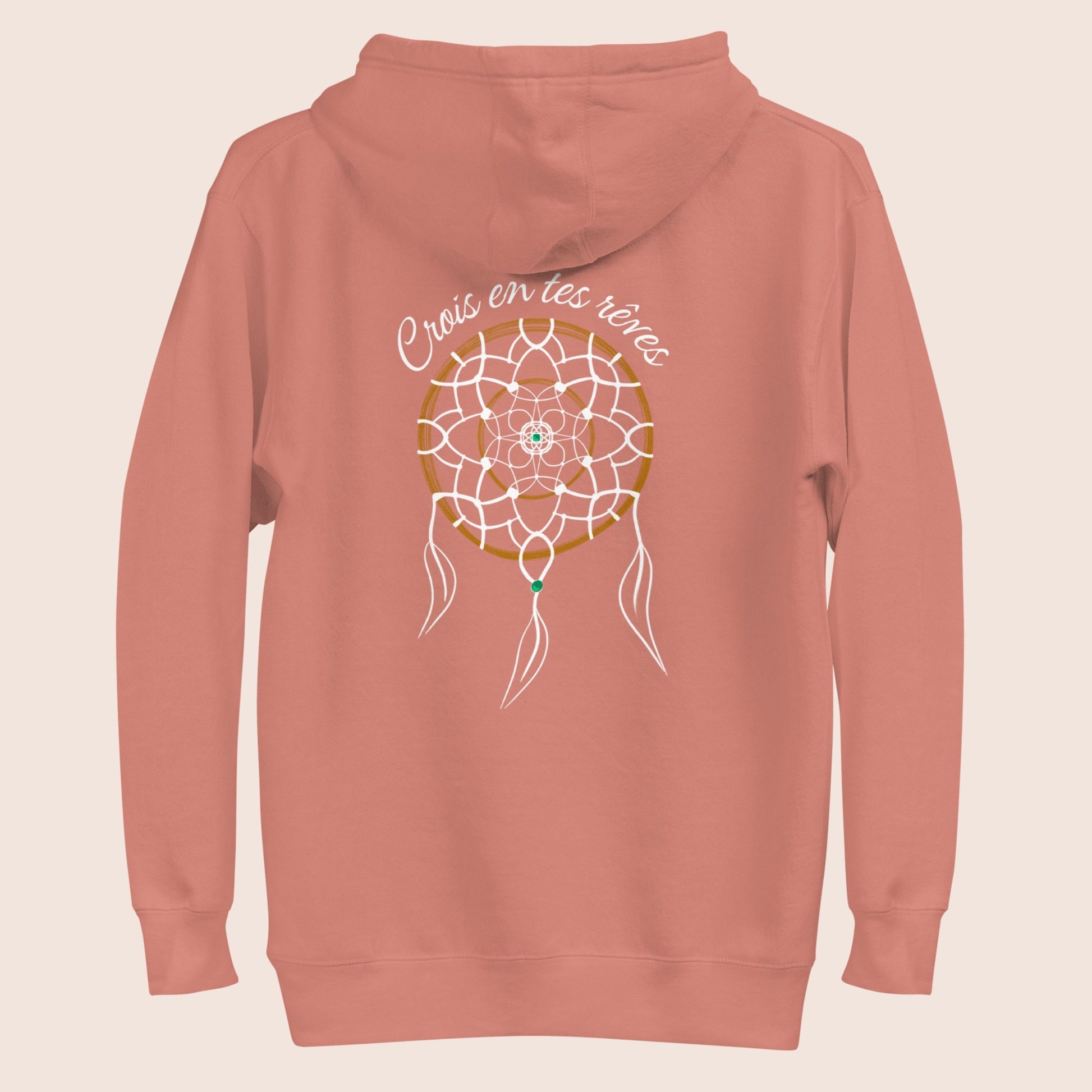 Sweat à capuche   non genré, avec message de motivation dans le dos Crois en tes rêves et symbolique graphique de l'attrape rêve sur fond rose poudré. Logo brodé Flame and Spirit poitrine gauche.