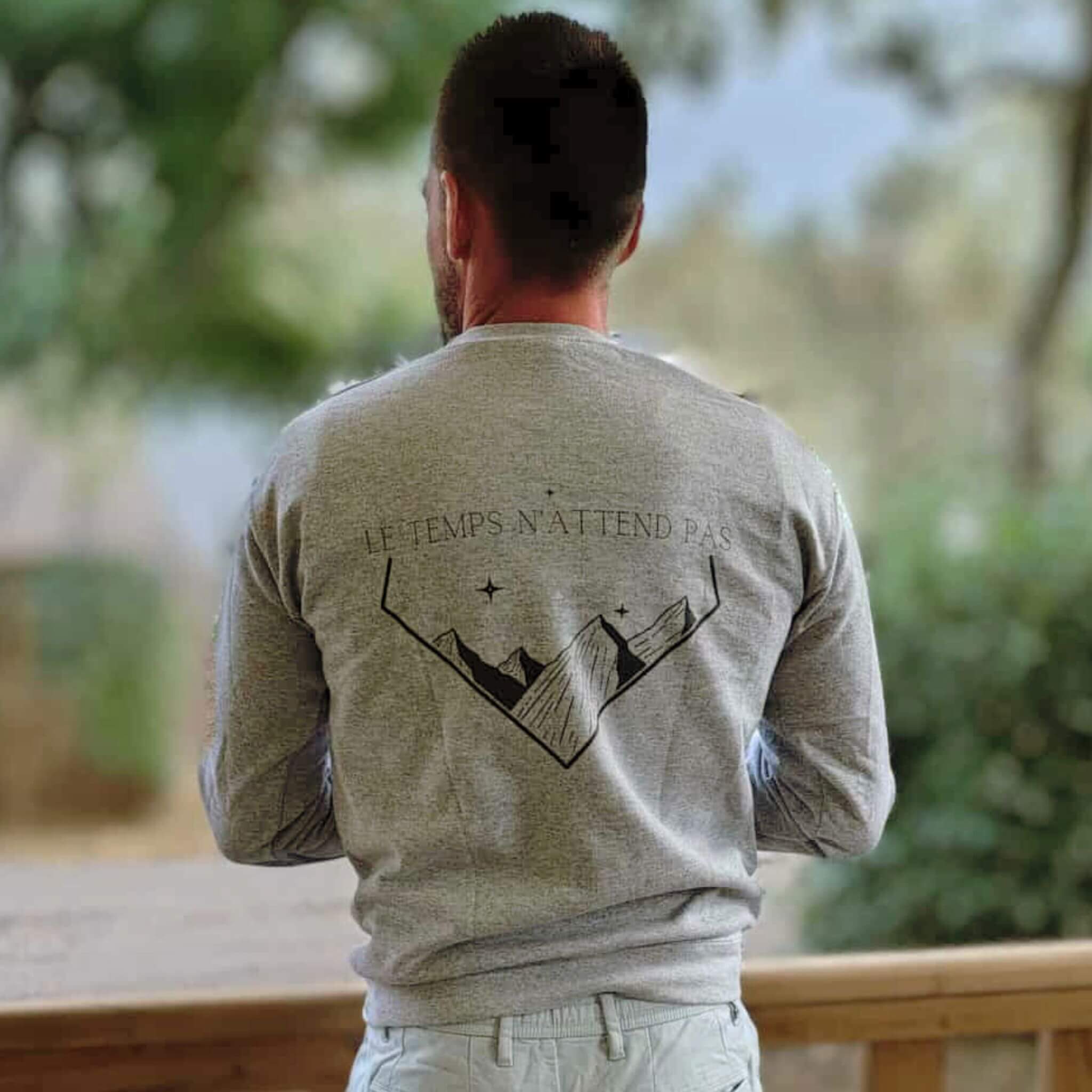 Sweat-shirt unisexe, avec phrase d'inspiration dans le dos Le temps n'attend pas et symbole de montagnes graphique noir sur fond gris clair. Logo brodé Flame and Spirit poitrine gauche.