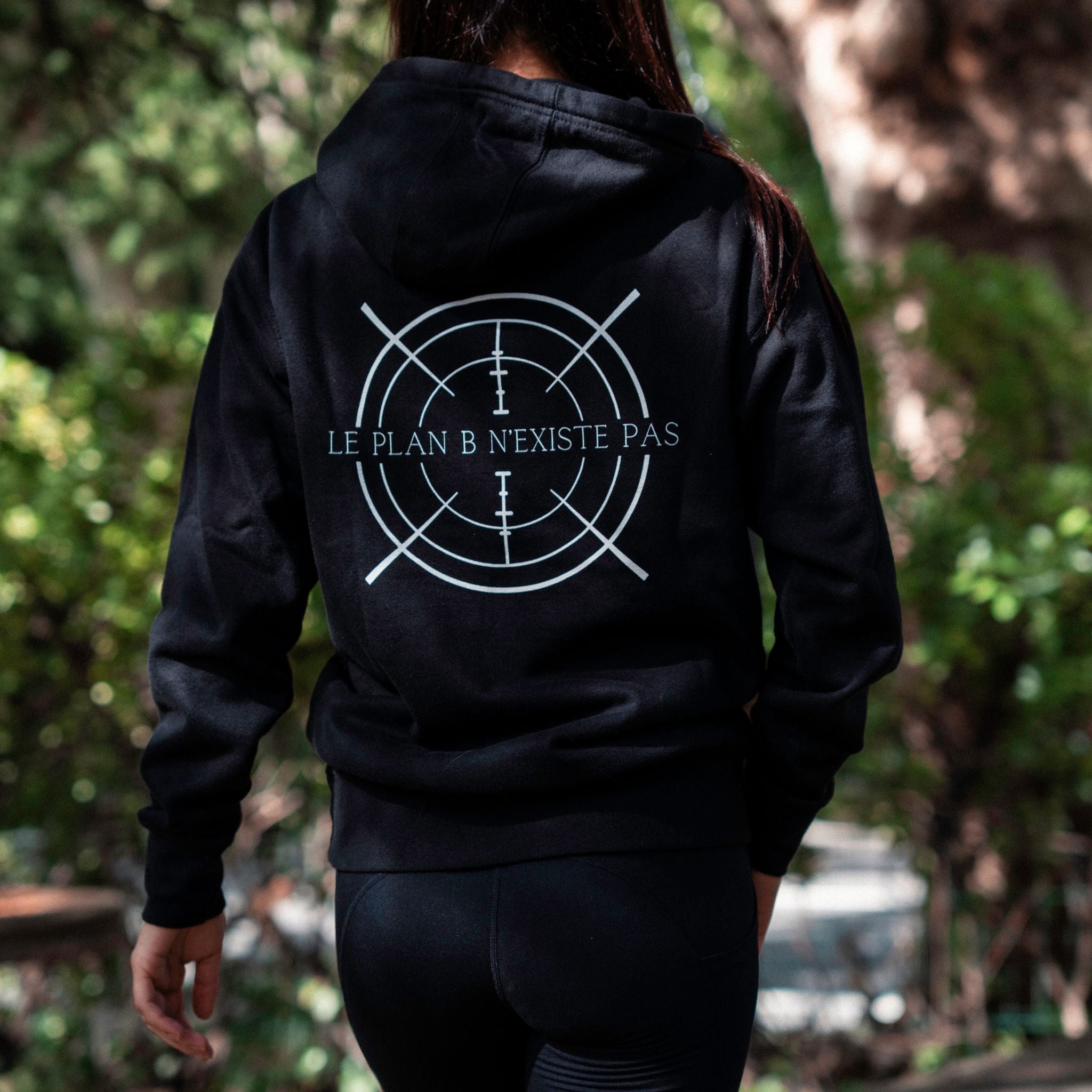 femme de dos qui porte le sweat a capuche noir Le plan B n'existe pas