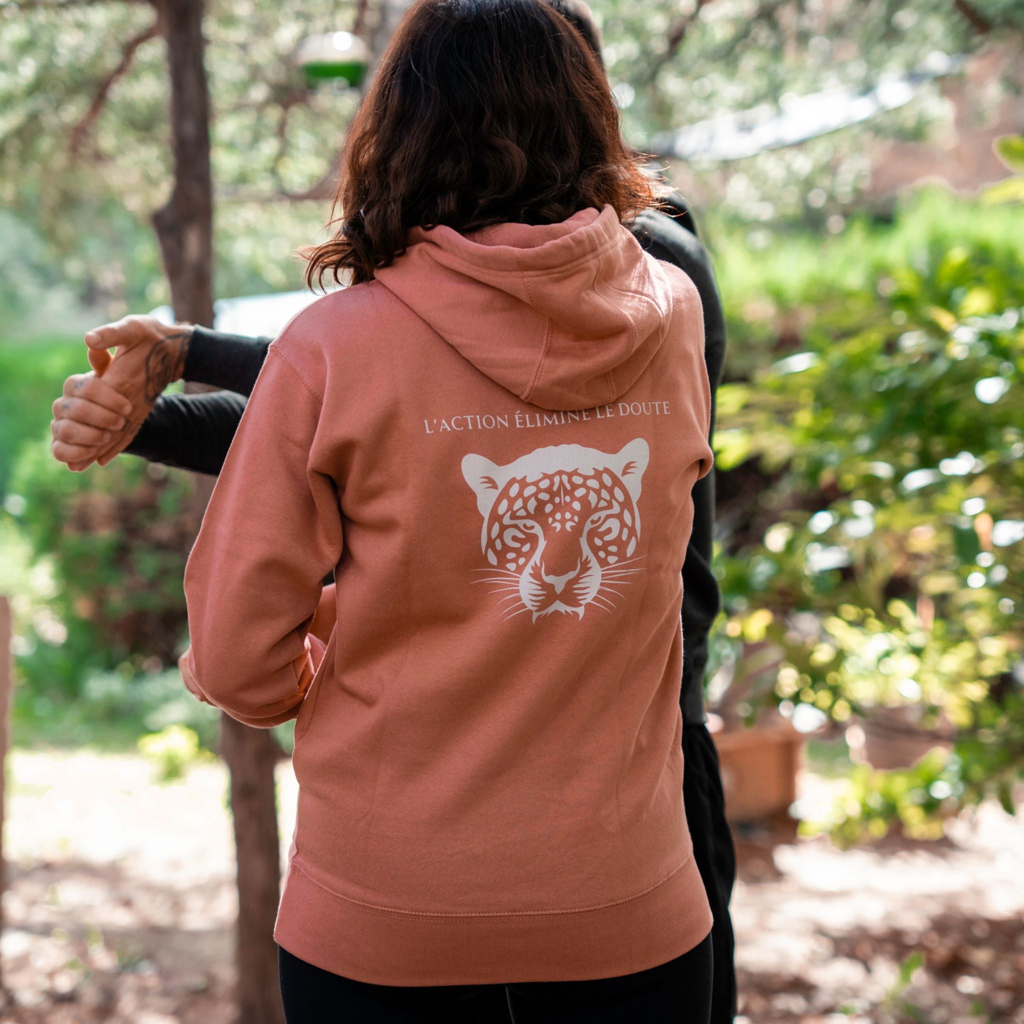 Personnes de dos l'une porte le sweat à capuche rose l'action élimine le doute