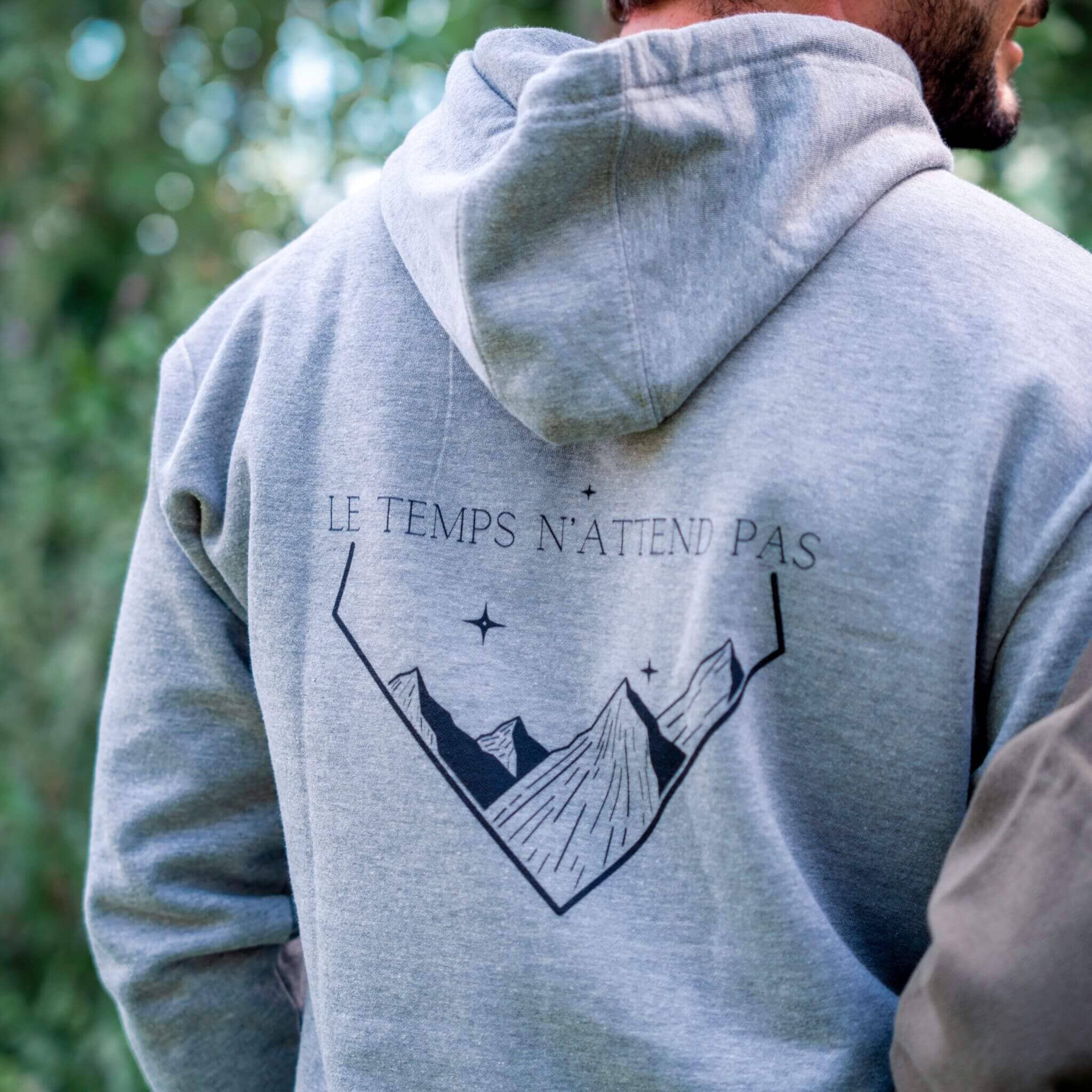 Sweat à capuche gris Flame & Spirit avec illustration de montagnes et inscription "Le temps n’attend pas" sur le dos.